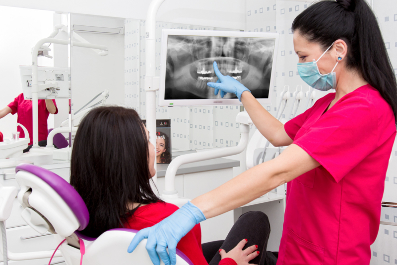 doamna doctor stomatologMirela Zaharia oferind explicatii pe o radiografie dentara